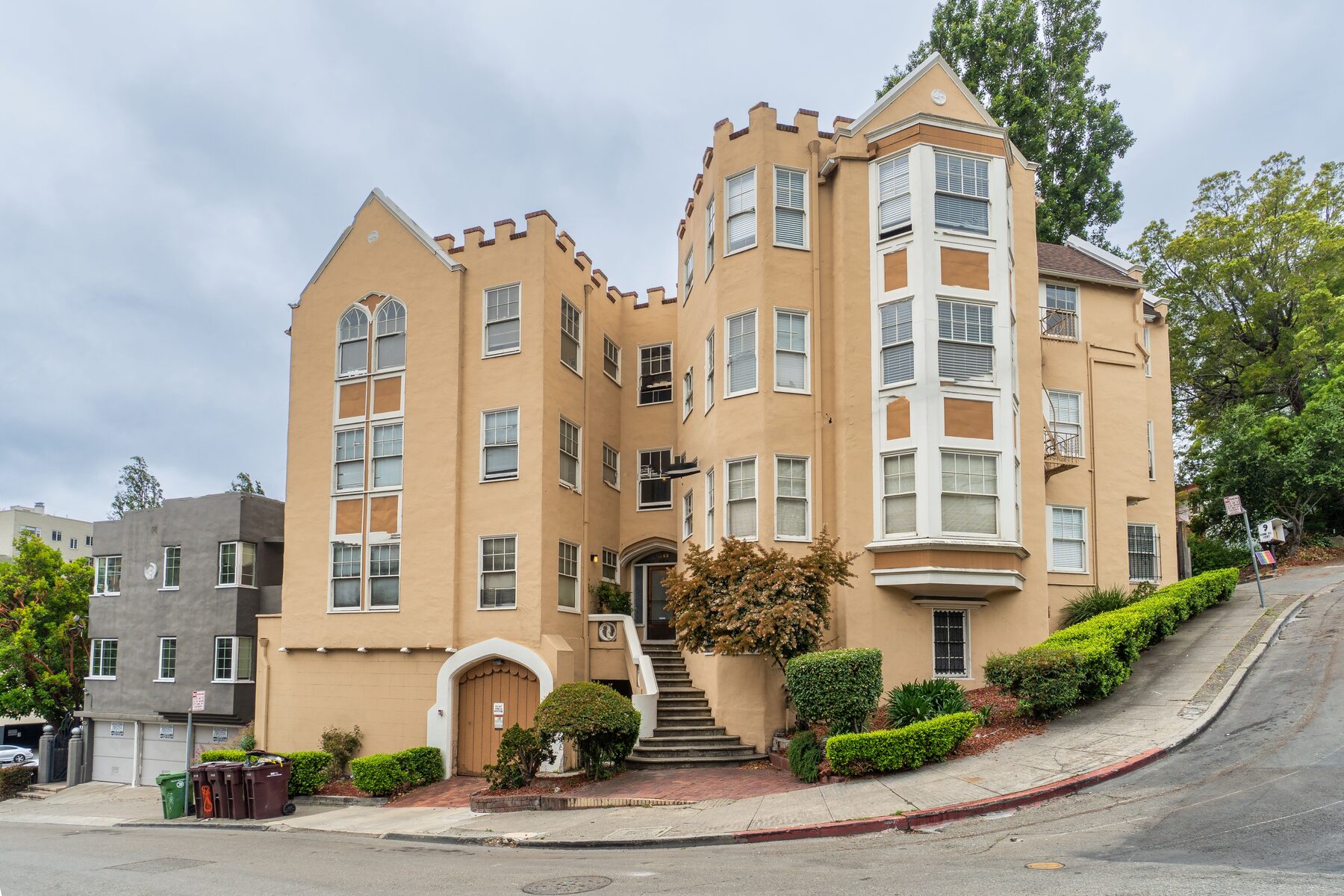 Castellated stucco apartment building on a hillside corner