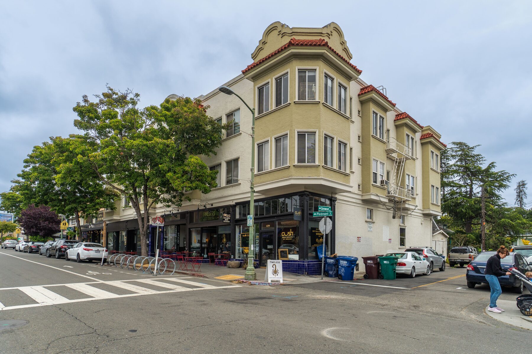 Corner building with red tile roof above neighborhood storefronts