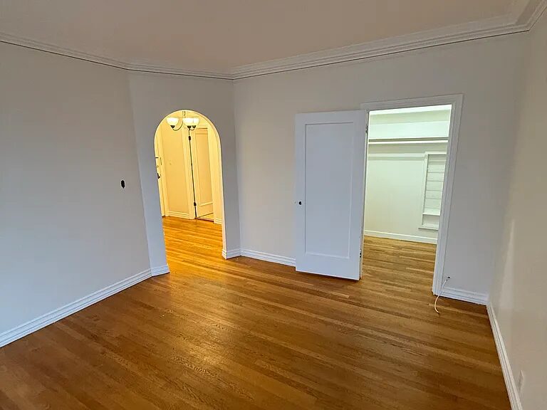 Main room with an arched doorway through to the entry and a closet