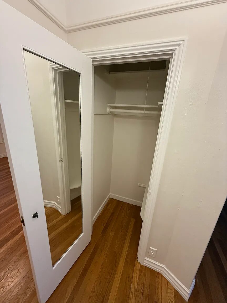 Closet with hanging rail and a full-length mirrored door